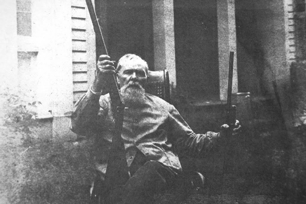 Old Man on a Porch with two shotguns